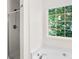 Updated bathroom boasts a sleek glass shower and a garden view window at 4292 Hurt Bridge Rd, Cumming, GA 30028