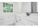 Modern bathroom featuring a large window, tub, and sleek countertops at 4292 Hurt Bridge Rd, Cumming, GA 30028