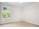 Cozy bedroom features a large window bringing in natural light and neutral carpeting at 4292 Hurt Bridge Rd, Cumming, GA 30028