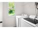 Bright laundry room features side-by-side appliances and natural light from the window at 4292 Hurt Bridge Rd, Cumming, GA 30028