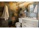 Stylish bathroom featuring unique slate tile walls, a modern vanity, and a round mirror at 30 5Th Ne St # 1010, Atlanta, GA 30308