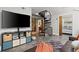 Bright living room featuring a black leather couch, television, spiral staircase, and decor at 30 5Th Ne St # 1010, Atlanta, GA 30308