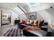 Bright living room featuring a comfortable black leather couch, area rug, and skylights for natural light at 30 5Th Ne St # 1010, Atlanta, GA 30308