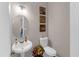 Well-lit powder room with a pedestal sink, toilet, decorative artwork, and floral arrangement at 3123 Wolf Club Dr. Sw, Atlanta, GA 30349