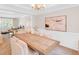 Elegant dining room with a large wooden table, wainscoting, and an open view into the living room at 3123 Wolf Club Dr. Sw, Atlanta, GA 30349