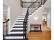 Bright foyer featuring a staircase with black railings, hardwood floors, and a view into the dining area at 3123 Wolf Club Dr. Sw, Atlanta, GA 30349