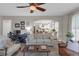 Bright living room features neutral decor, a ceiling fan, and an open floor plan leading to the kitchen at 3123 Wolf Club Dr. Sw, Atlanta, GA 30349