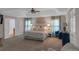 Spacious main bedroom featuring a tray ceiling, fan, large windows, and elegant furnishings at 3123 Wolf Club Dr. Sw, Atlanta, GA 30349