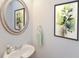 This well-lit bathroom features a round mirror, modern artwork, and a sleek undermount sink at 45 Chimney Ridge Ln, Covington, GA 30014