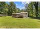 Lush backyard with a large, well-maintained lawn, a screened porch, and a wooden deck at 231 Cross Gate Dr, Marietta, GA 30068
