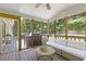 Relax on this porch with an outdoor sofa, ceiling fan, and view of lush greenery at 231 Cross Gate Dr, Marietta, GA 30068