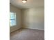 Cozy bedroom with a large window, carpet, and light-colored walls at 3536 Dogwood Pass, Lithonia, GA 30038