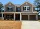 Charming two-story home with a brick and siding facade, a covered porch and a two-car garage at 3536 Dogwood Pass, Lithonia, GA 30038