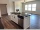 Spacious kitchen island with sink, dishwasher, and sleek countertops adjacent to a bright living area at 3536 Dogwood Pass, Lithonia, GA 30038