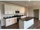 Modern kitchen with white cabinets, stainless steel appliances, and a center island with black countertops at 3536 Dogwood Pass, Lithonia, GA 30038
