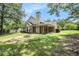 Lush backyard featuring mature trees and exterior view of the home with a patio area at 55 Ashland Farm Rd, Oxford, GA 30054