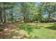 Expansive backyard featuring mature trees, lush lawn, and play structures at 55 Ashland Farm Rd, Oxford, GA 30054