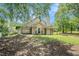 Spacious backyard with mature trees and view of house with porch and patio at 55 Ashland Farm Rd, Oxford, GA 30054