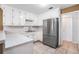 Well-lit kitchen features white cabinets, stainless steel appliances and tiled flooring at 55 Ashland Farm Rd, Oxford, GA 30054