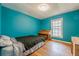 Bedroom features hardwood floors and a bright blue accent wall with a large window at 5709 Center Hill Church Rd, Loganville, GA 30052