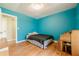 Well-lit bedroom with vibrant blue walls, wood floors, and natural light at 5709 Center Hill Church Rd, Loganville, GA 30052