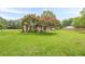 Lush front yard, adorned with mature trees and flowering shrubs, adds curb appeal at 5709 Center Hill Church Rd, Loganville, GA 30052
