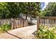 Gated driveway entrance with blossoming flowers, leading to a private home with a detached garage and rear yard at 2010 2Nd Ave, Decatur, GA 30032