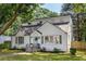 A bright white brick home with dormer windows and a charming blue door, surrounded by a well-kept lawn at 2010 2Nd Ave, Decatur, GA 30032