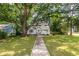 Charming white home with a quaint blue door, nestled under a large tree with a sprawling green lawn at 2010 2Nd Ave, Decatur, GA 30032