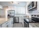 Well-lit kitchen featuring stainless steel appliances, including a range, microwave, and a granite island countertop at 2010 2Nd Ave, Decatur, GA 30032