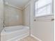 This bathroom features a shower-tub combo with tiled walls and a window for ventilation at 232 Oconee Way, Canton, GA 30114
