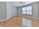 Cozy bedroom with gray walls, ceiling fan, bright window, and pristine wood flooring at 232 Oconee Way, Canton, GA 30114