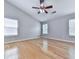 This bedroom features a ceiling fan, wood floor, and multiple windows for natural light at 232 Oconee Way, Canton, GA 30114