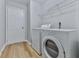 Convenient laundry room featuring modern washer and dryer set with durable wood flooring at 232 Oconee Way, Canton, GA 30114