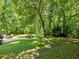 Backyard view showcasing the well-manicured lawn, a picnic table, and wooded area at 5020 Bayberry Dr, Cumming, GA 30040