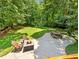 Backyard patio with a fire pit, seating, picnic table, and expansive lawn at 5020 Bayberry Dr, Cumming, GA 30040