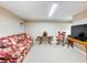 Finished basement with carpet, a television, a couch, a rocking chair, and fluorescent lighting at 5020 Bayberry Dr, Cumming, GA 30040