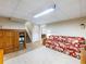 View of finished basement with floral sofa, wooden cabinet, and staircase at 5020 Bayberry Dr, Cumming, GA 30040