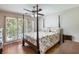 Bedroom with a four poster bed, hardwood floors, ceiling fan, and light from a window at 5020 Bayberry Dr, Cumming, GA 30040
