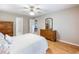 Bedroom with light gray walls, wood floors, ceiling fan, plus a doorway to another room at 5020 Bayberry Dr, Cumming, GA 30040