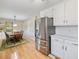 Open kitchen featuring stainless fridge, white cabinets, and a connecting breakfast area at 5020 Bayberry Dr, Cumming, GA 30040