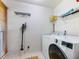 Bright laundry room with a front-load washer, white wire shelving and a window for natural light at 5020 Bayberry Dr, Cumming, GA 30040