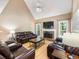 Cozy living room with stone fireplace, vaulted ceiling, and plush leather seating at 5020 Bayberry Dr, Cumming, GA 30040