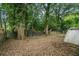 Spacious backyard with mature trees, chainlink fence, and an exterior storage structure at 724 Bellemeade Nw Ave, Atlanta, GA 30318