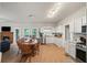 Bright eat-in kitchen with white cabinets, stainless appliances, and adjacent fireplace seating area at 740 Paris Dr, Lawrenceville, GA 30043