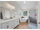 Main bathroom with a tub, standing shower, and double vanity sinks at 740 Paris Dr, Lawrenceville, GA 30043
