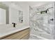 Modern bathroom with marble tile shower, white vanity, and black hardware at 8649 Cedar Creek Rdg, Riverdale, GA 30274