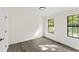 Bright bedroom featuring grey vinyl floors, neutral paint, and natural light from two windows at 8649 Cedar Creek Rdg, Riverdale, GA 30274