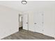 Modern bedroom with grey vinyl floors, neutral paint, and two doors at 8649 Cedar Creek Rdg, Riverdale, GA 30274