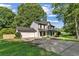 Two-story home with a large driveway and a well-manicured lawn surrounded by mature trees with an attached garage at 8649 Cedar Creek Rdg, Riverdale, GA 30274
